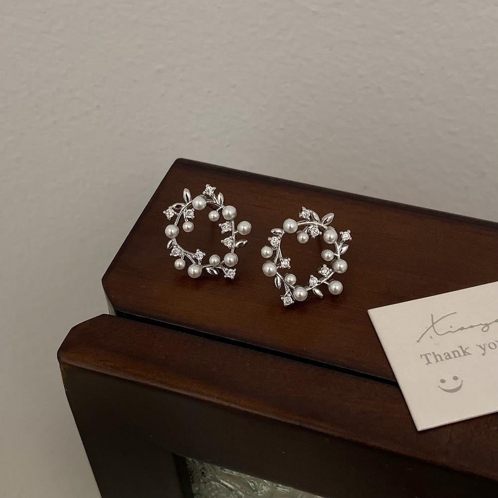 Aretes circular elegantes de perlas y hojitas